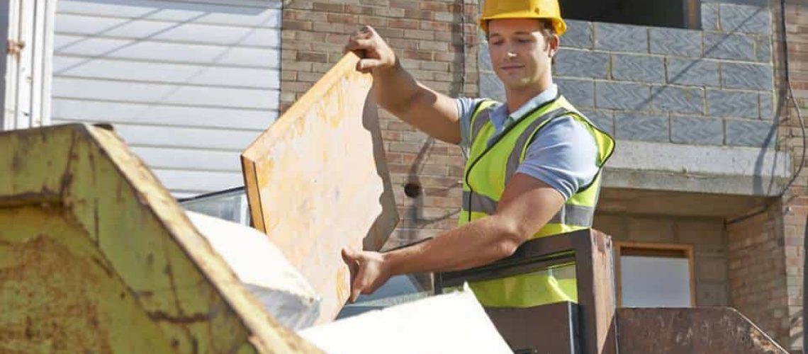 builder throwing away waste into a skip